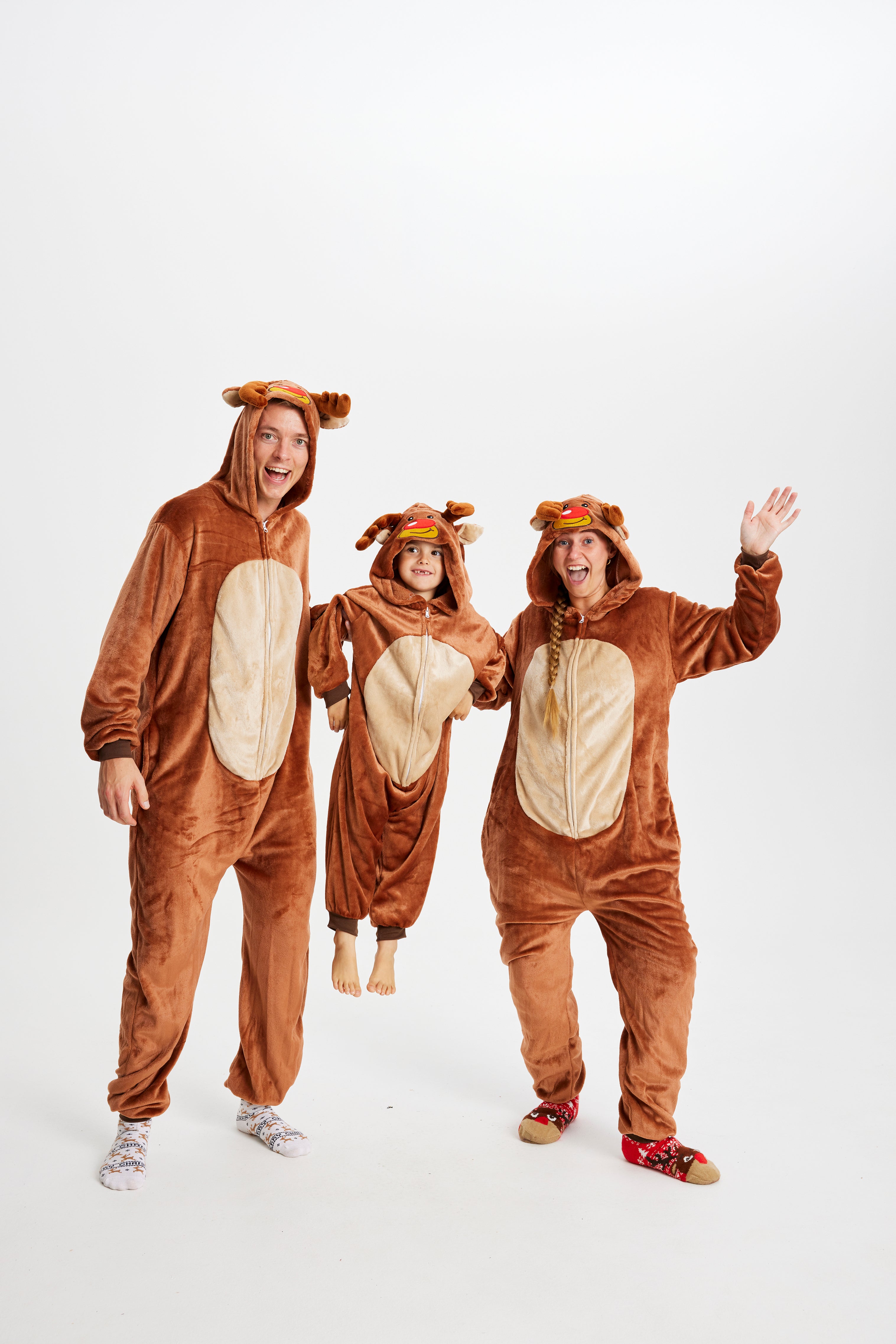 En mand, dame og et barn er alle iført samme brune sweatsuit med Rudolf-tema.